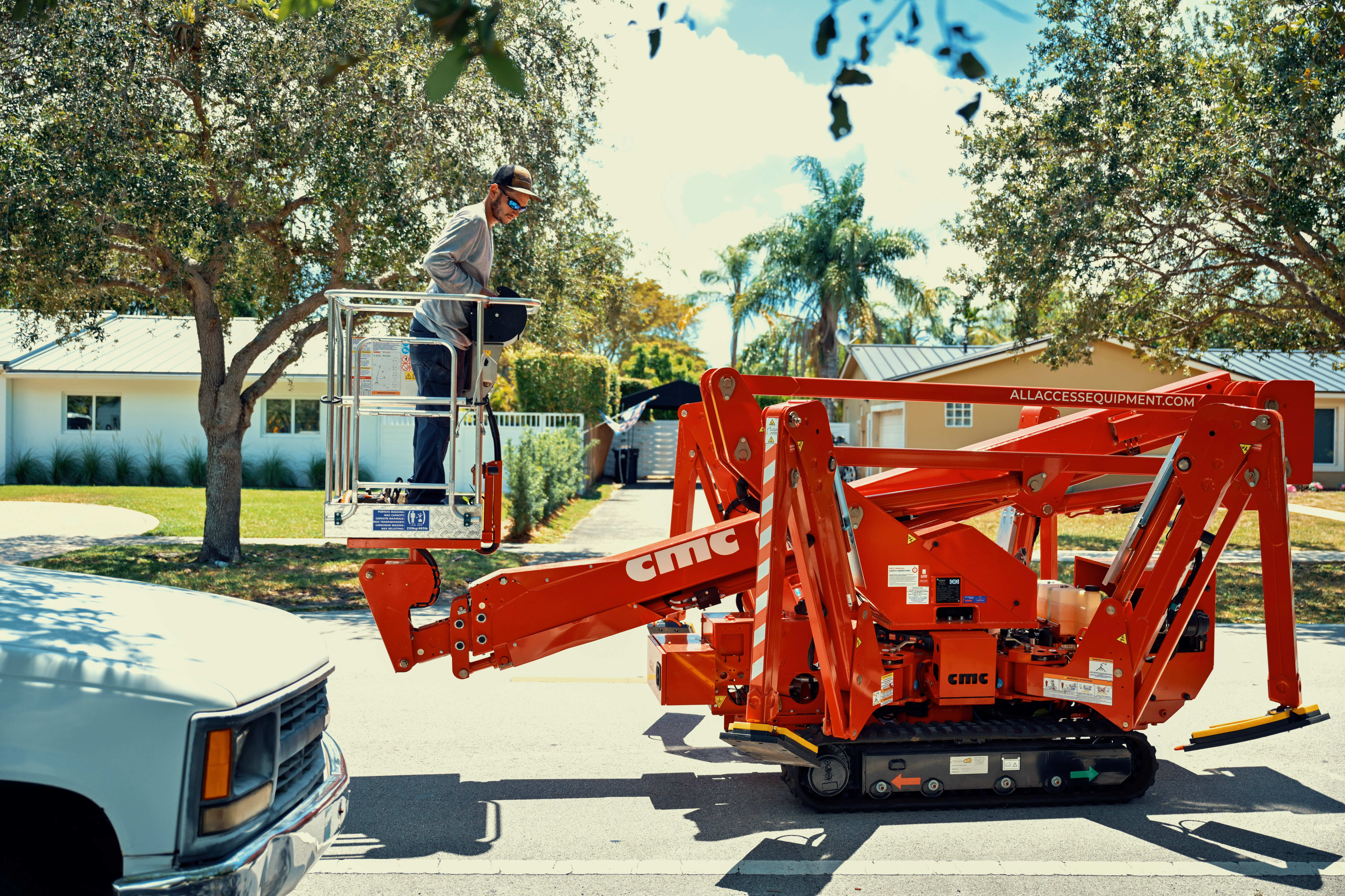 Professional tree service worker in a spider lift